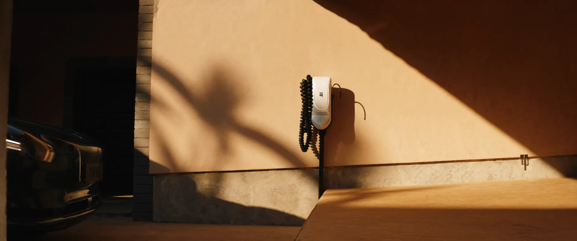 Borne de recharge murale installée sous le carport d'une villa marocaine